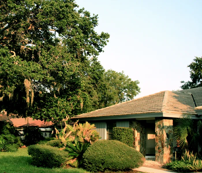 home with well trimmed bushes and trees